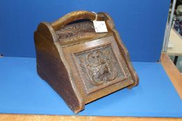 A 19th c heavily carved Black Forest style coal scuttle.