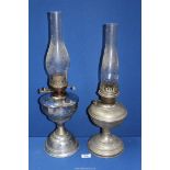 Two chrome effect oil lamps with chimneys , one being Aladdin.
