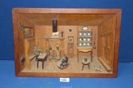 A Black Forest carved Diorama of a room interior with a Grandfather clock, dresser and two figures,