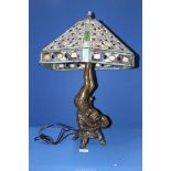 A Tiffany style lamp with ornate stained glass shade with base featuring a gymnast,