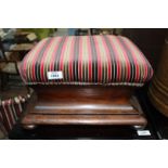 A Mahogany framed Footstool of elegant shape standing on compressed bun feet and upholstered in