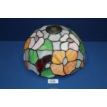 A Tiffany style lamp shade in mauve, orange, green and grey floral design, 10" diameter.