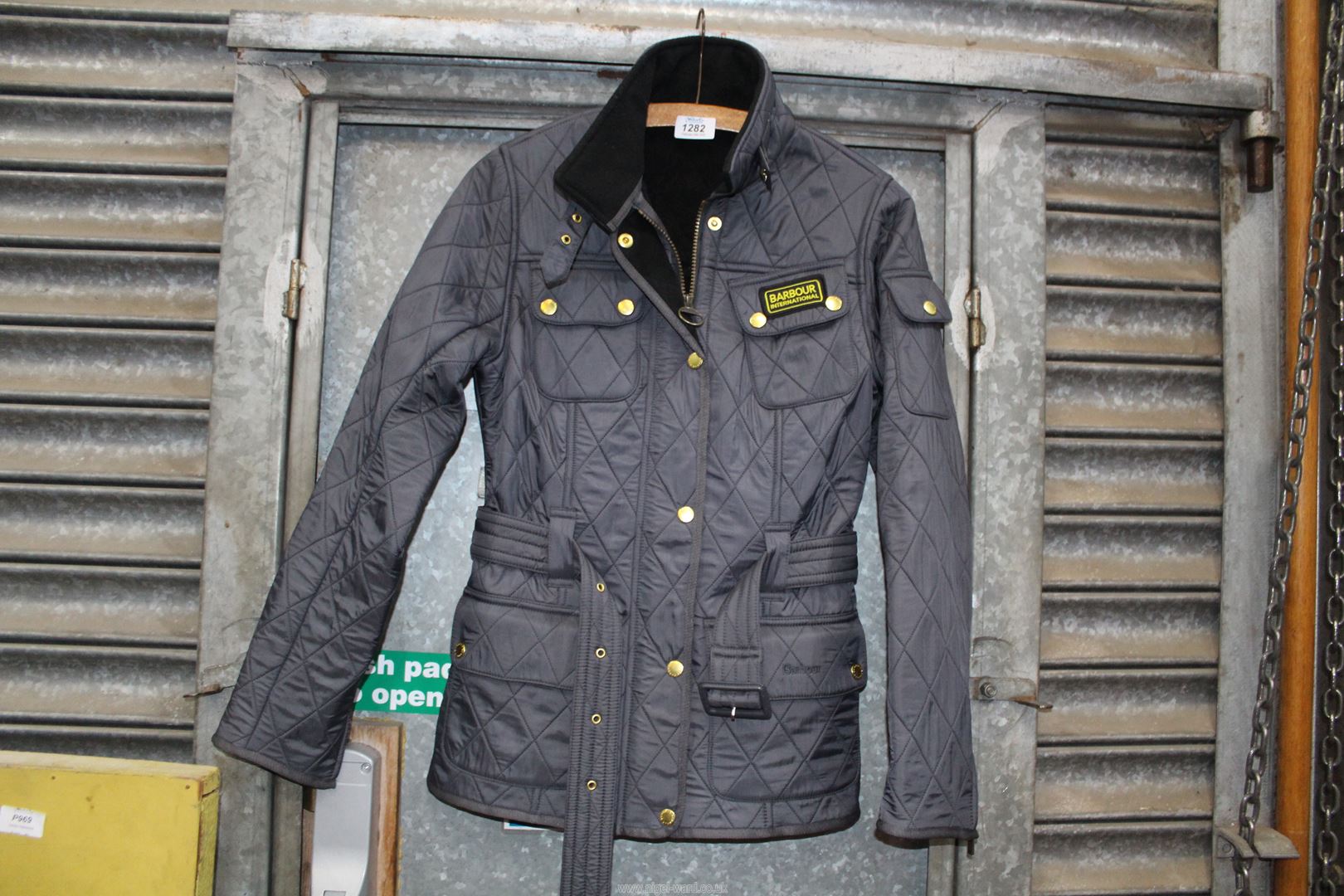 A ladies size 8 quilted Barbour jacket with belt in navy.