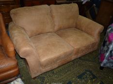 A light brown suede type upholstered two seater Settee, complete with two scatter cushions.