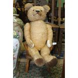 A large jointed Teddy Bear with glass eyes, had pads and ears replaced or repaired, well loved,