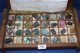 A wooden box containing a collection of mineral samples.