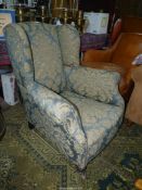 An elegant probably circa 1910 Wing fireside Chair upholstered in blue and beige fabric depicting
