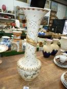 A tall and very heavy Chinoiserie vase in cream with a three claw golden dragon spiralling round