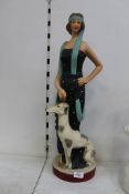 A ceramic figure of a 1920's lady with a greyhound, 25 1/4" tall.