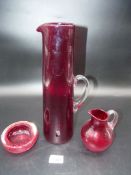 A trio of vintage White friars red Glass including a 13" tall tapered jug with clear handle,