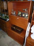 A teak wood finished Lounge Unit with lower cupboard, fall front, drinks cabinet and shelving over,