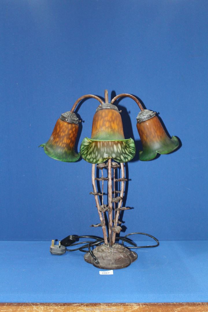 A three branch Lily table lamp having a cast metal floral base and green/orange shades, - Image 2 of 2