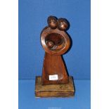 An interesting modernist soft wood carving of parents holding a baby in arms in the style and