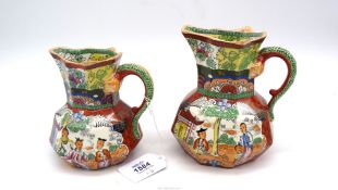 A graduated pair of Mason's jugs with octagonal shaped bodies decorated with oriental scenes on