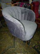A modern tub shaped Easy Chair upholstered with grey suede style upholstery and standing on