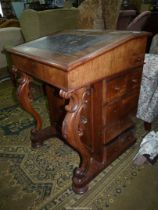 A mixed woods Davenport, the tooled lined slope lifting to reveal an interior with four drawers,