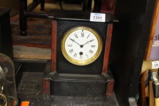 A slate and brown polished stone Mantle Clock having Roman numerals on a white face, back fixed,