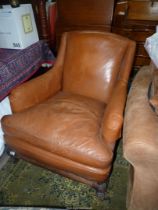 An old but very comfortable mid brown leather upholstered deep-seated Armchair complete with arm