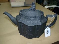 A black basalt teapot having lobed oval body, sprigged on one side with a woman and child,