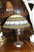 A Tiffany style table lamp with shade of white, blue and yellow patterns, 15" tall.