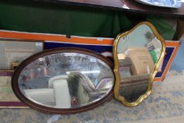 A shaped gilt mirror, 27'' high x 19'' and an oval bevel plated mirror, 29 1/2'' x 19''.