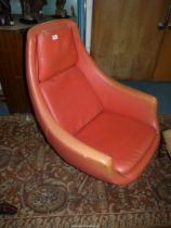 A stylish and believed 1960's orange upholstered egg shaped Tub Armchair having swivel action to