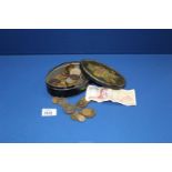 A metal tin of assorted coins including sixpences, Victorian coins and a 100 Greek note.