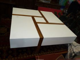 A designer Coffee Table having four all-round sliding cover storage compartments finished in gloss