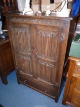 An Old Charm/Priory Oak style Cupboard with linen fold details,