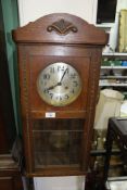 An Oak cased Wall Clock having a silvered face with Arabic numbers,