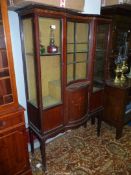 A circa 1900/1910 display cabinet having an inlaid decorated bowed central section cupboard with *