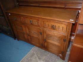 An Old Charm/Priory type Sideboard having three cupboards and three drawers over,