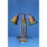 A three branch Lily table lamp having a cast metal floral base and green/orange shades,