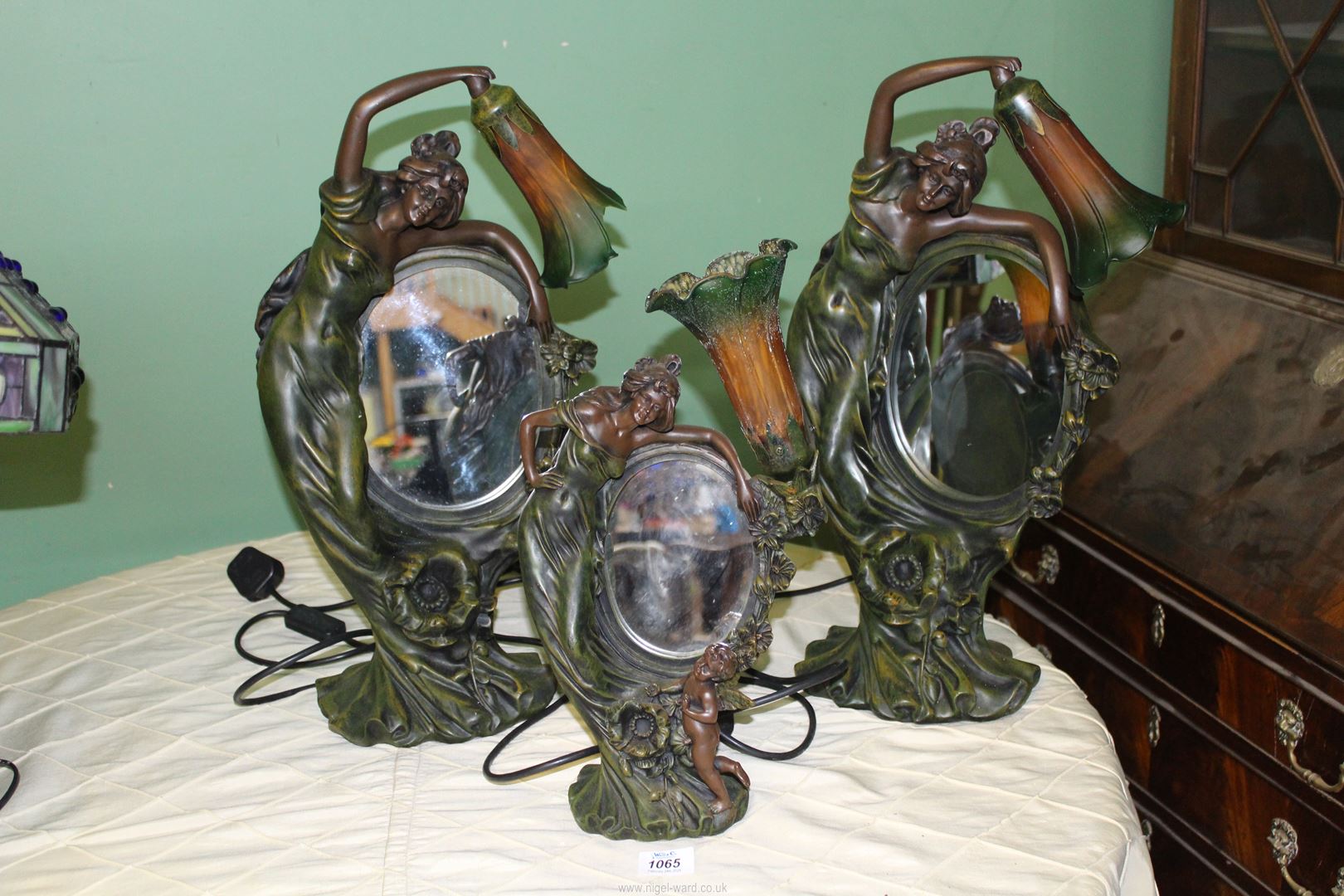 A pair of Figural Lamps of a Lady arching over a mirror with green and orange shade,