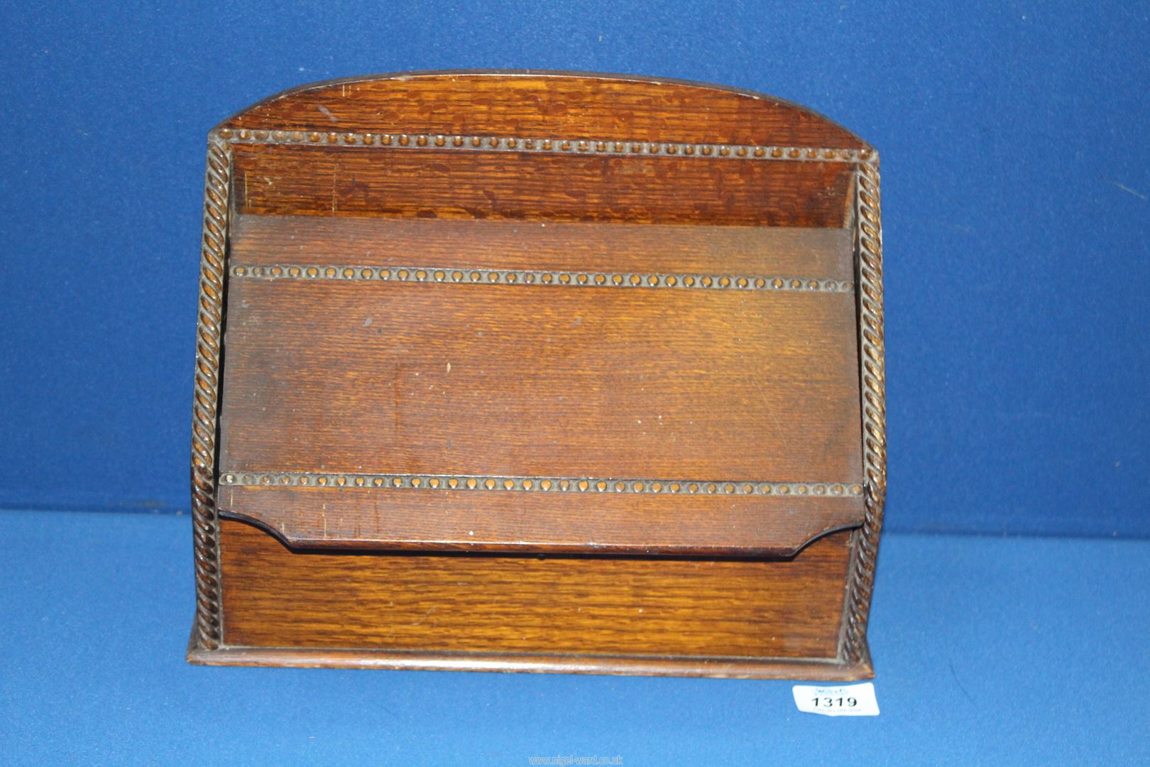 A oak 1930's letter holder having a sliding lid, 12 1/2" x 4 1/4" x 10 1/8" high.