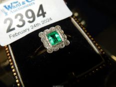 An 18ct all gold Emerald and Diamond ring with princess cut emerald surrounded by 12 small diamonds,