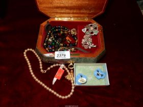 A musical jewellery box containing brooches, necklaces, pin badges,