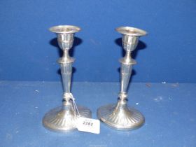 A pair of weighted Silver Candlesticks with reeded conical shape stems on oval inverted ribbed