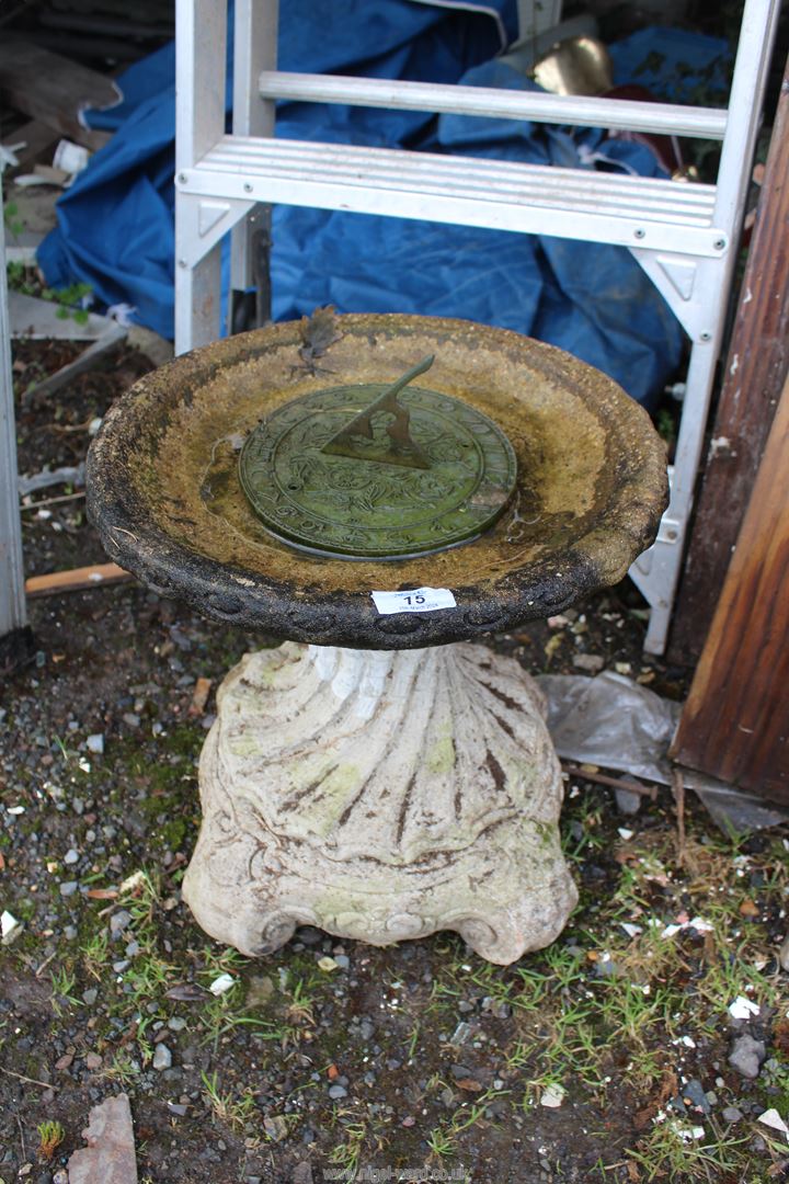 Concrete bird bath with sundial, 16'' high x 14'' diameter.