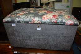 A Ottoman having a fabric seated top.