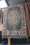 A Crewel work Rug having central panel of stylised flowers and foliage on mounted green ground