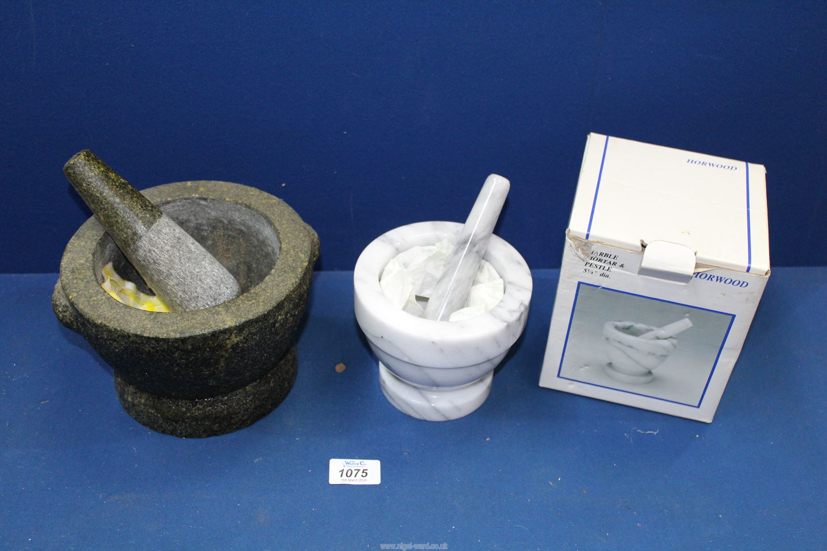 A stone pestle & mortar and a marble pestle & mortar.