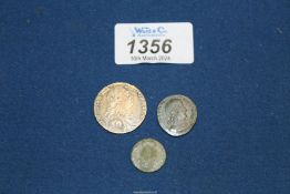 A George III shilling, 1787 and two Roman Coins.