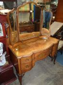 A cross-banded Walnut serpentine topped Dressing Table having one long and four short drawers,