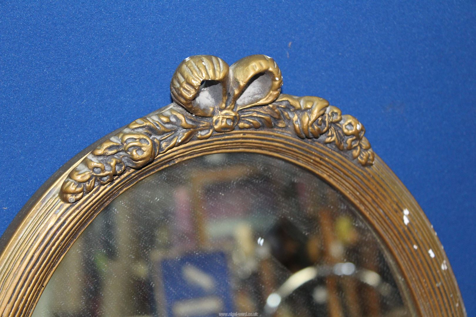 A small reeded and gilded frame oval mirror with bow pediment, 17" x 12 3/4". - Image 2 of 3