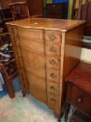 A cross-banded Walnut serpentine fronted Tallboy of six drawers having pierced backplate drop