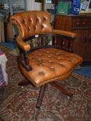 A brown hide upholstered buttoned detailed swivel and tilt Office Armchair,