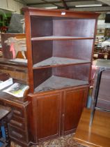 A Mahogany Corner Cupboard having a pair of opposing panelled lower doors,