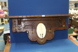 An Oak wall hanging hall Mirror/Shelf with coat hooks and mirror, 40'' wide x 18'' high.