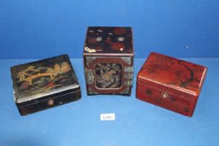 Three early 20th Century lacquer boxes in maroon and black decorated with traditional trailing